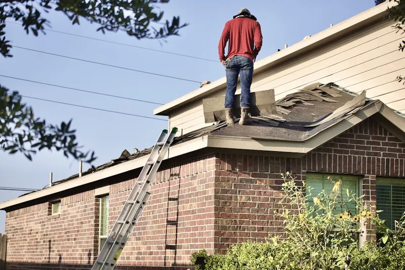 Professional roofer working on a residential roof in College Town